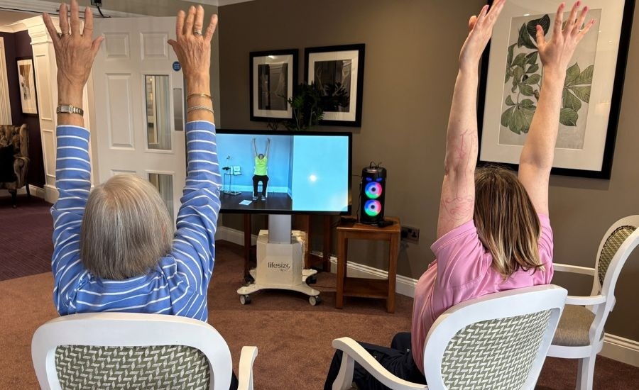 Care home residents doing armchair exercises on the Lifesize Happi Table